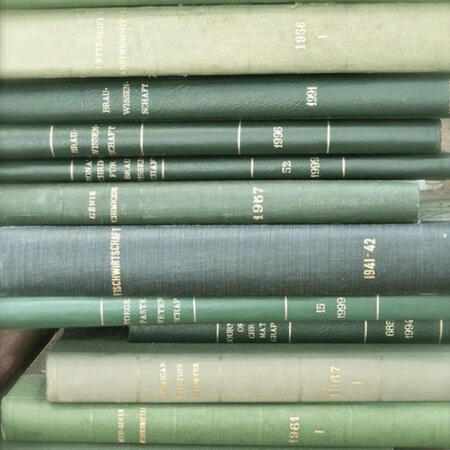A stack of green books, facing spine-out toward the camera